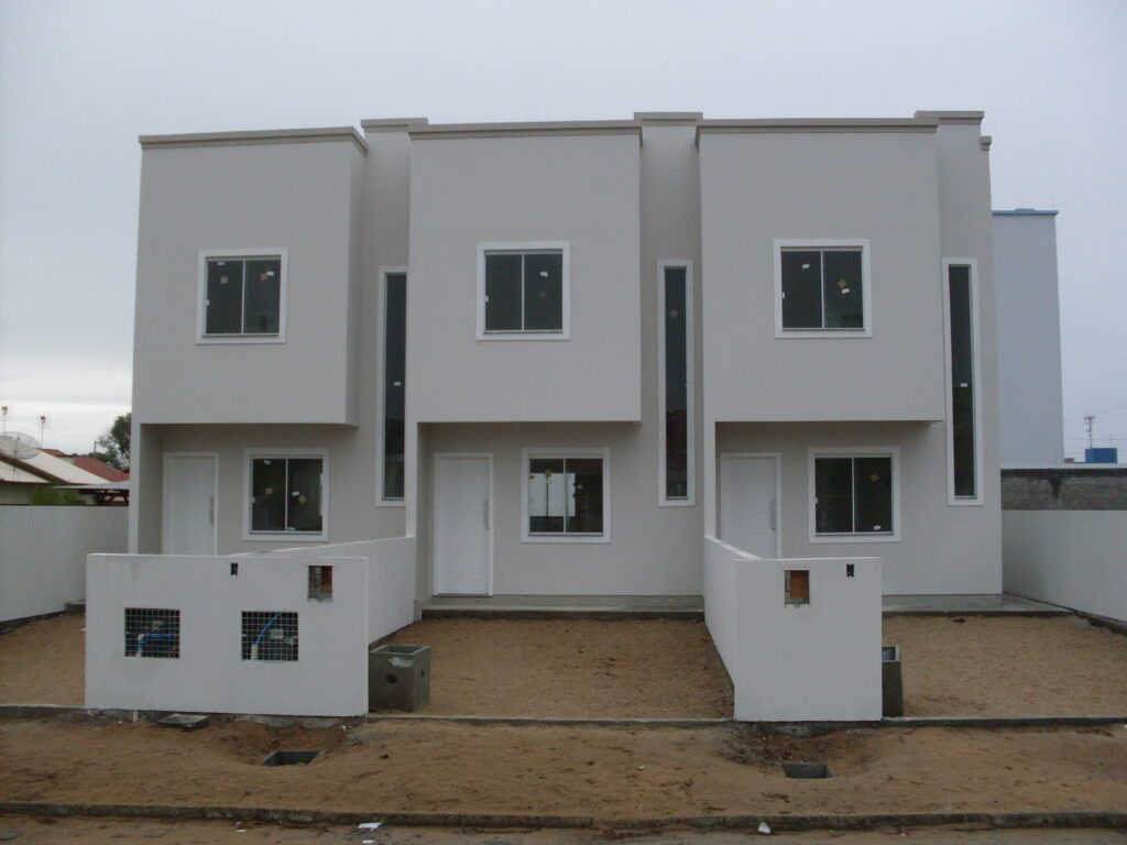 Fachada frontal do Residencial Rosa dos Ventos I com três unidades geminadas e acabamento em tons neutros